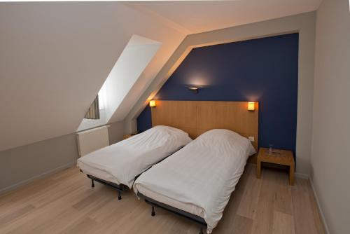 赫伦塔尔斯Hotel De Zalm的一间卧室设有一张床和蓝色的墙壁