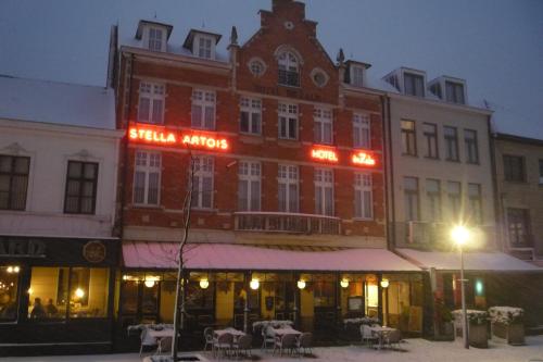 赫伦塔尔斯Hotel De Zalm的一座大砖砌建筑,上面有 ⁇ 虹灯标志