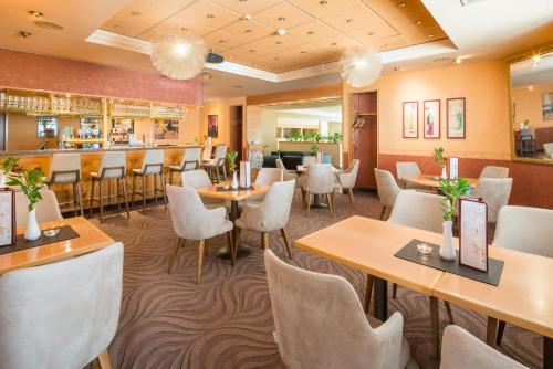 耶拿耶拿贝斯特韦斯特酒店的一间带桌椅的餐厅和一间酒吧