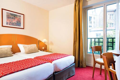 巴黎莫迪利亚尼别墅蓝色假日酒店的酒店客房设有床、桌子和窗户。