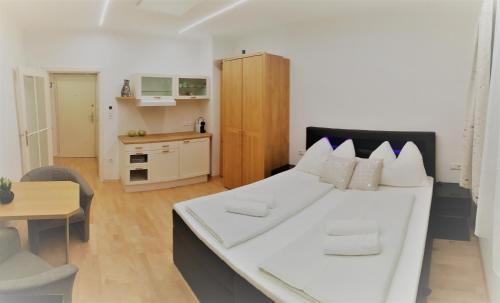 维也纳Vienna City Apartment in Mariahilfer Straße的带厨房的客房内一张大白色的床
