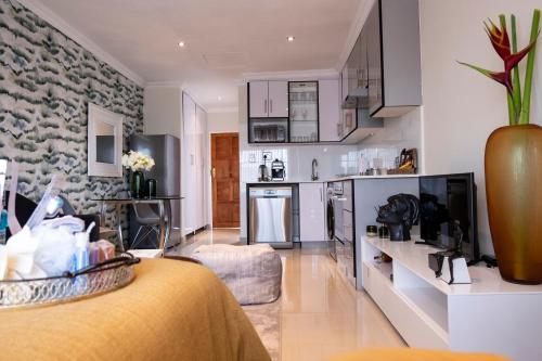 RandjesfonteinThe Wilcrest Apartment的一间带厨房的客厅和一间带沙发的房间
