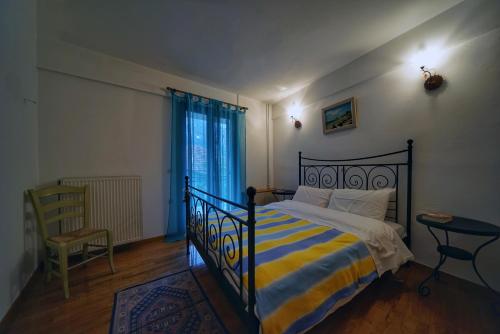 埃普塔罗弗斯Elatos Guest House的一间卧室配有一张带黄色和蓝色条纹毯子的床