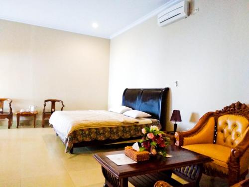 BaubauNirwana Buton Villa的卧室配有1张床、1张桌子和1把椅子
