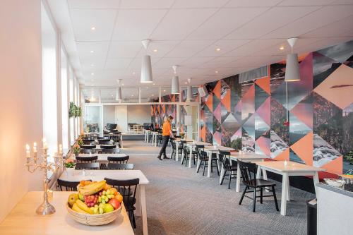 于默奥Norrland YMCA Hostel Umeå的一间食堂,配有桌椅和一碗水果