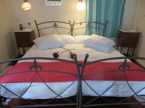Saaxumhuizen菲尼斯特雷住宿加早餐旅馆的一张带红色和白色棉被的大床