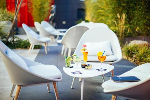 斯特拉斯堡Hôtel Restaurant Athena Spa的一组桌椅,上面有饮料