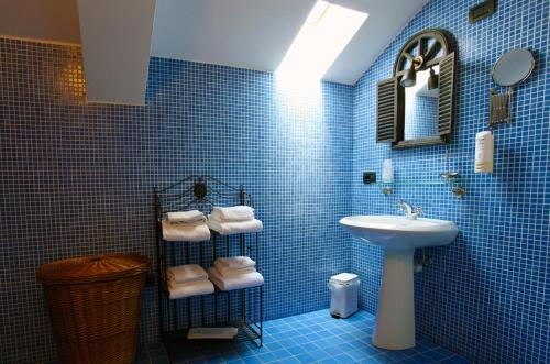 科利科里西酒店的蓝色瓷砖浴室设有水槽和镜子