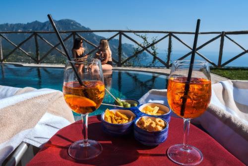 拉维罗花园酒店的池畔餐桌旁的两杯葡萄酒和小吃