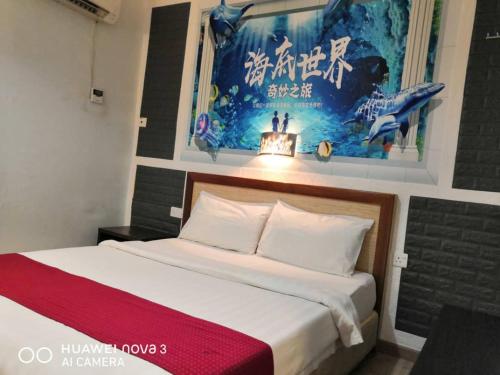 古晋兆丰旅馆的卧室配有一张壁挂式海报的床