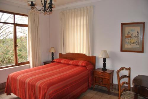 科罗伊科科罗伊科凯莱大酒店的一间卧室设有红色的床和窗户。