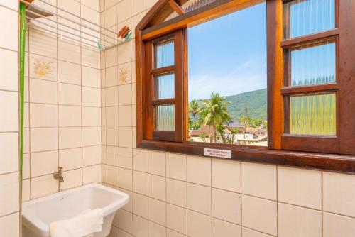 乌巴图巴Chalés Four Seasons的带浴缸的浴室和窗户。