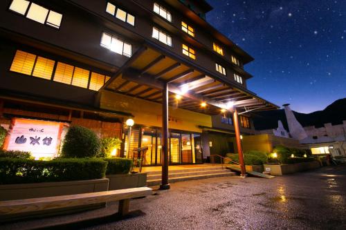 由布市汤布院山水馆日式旅馆的一座在晚上有长凳的建筑