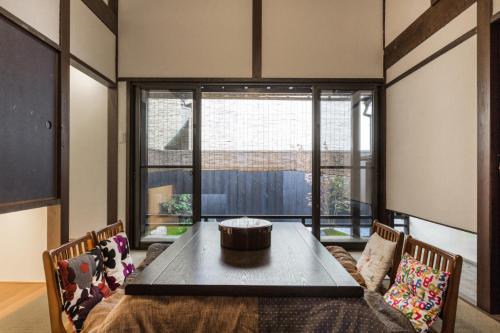 京都京町家一棟貸しKyoto Machiya Stay En的一间带桌子和大窗户的用餐室