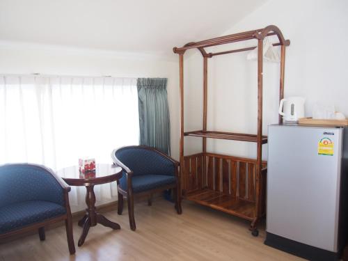 沙美岛农略客房酒店的配有冰箱和桌椅的客房