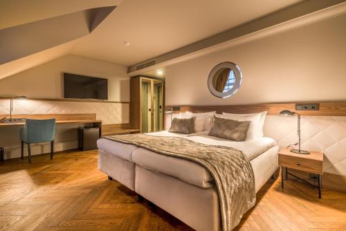 维尔纽斯Hotel Vilnia的一间卧室配有一张床、一张桌子和一张桌子