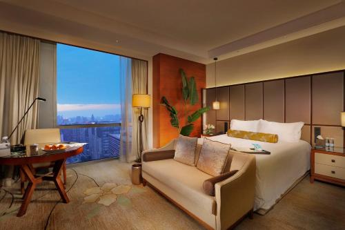 东莞东莞康帝国际酒店的一间卧室配有一张床、一把椅子和一张书桌