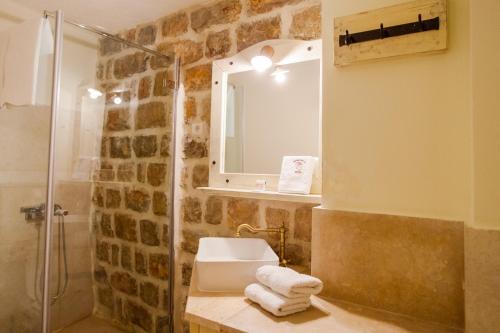 佩特罗瓦纳莫鲁Pietra Mare Apartments的带淋浴、盥洗盆和镜子的浴室