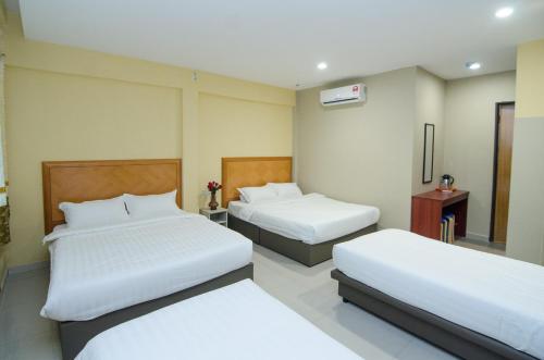 吉隆坡Hotel Raja Bot的酒店客房设有两张床和电视。