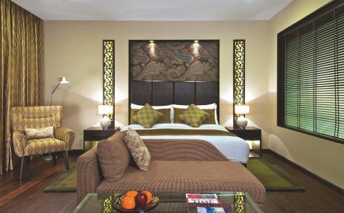 斯利那加Vivanta Dal View的一间卧室配有一张床、一张沙发和一把椅子