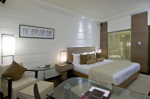 帕纳吉Vivanta Goa, Panaji的酒店客房配有床、沙发和桌子。