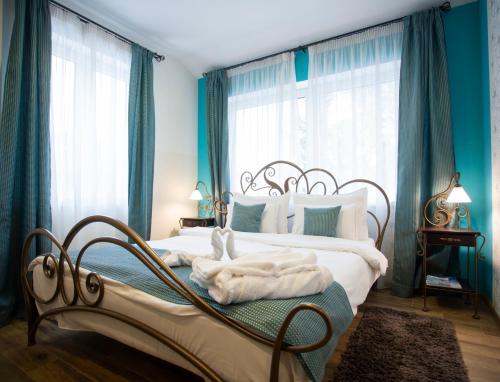 贝尔格莱德Hotel DUM的一间卧室设有两张带蓝色墙壁和窗户的床。