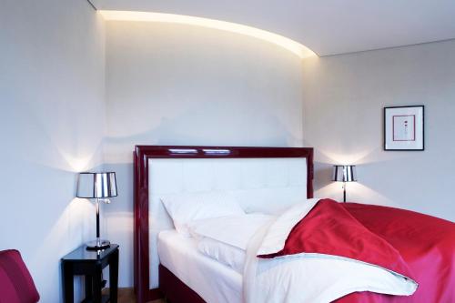 瓦尔德布龙仕维策尔公园酒店的一间卧室配有一张床铺,床上铺有红色毯子