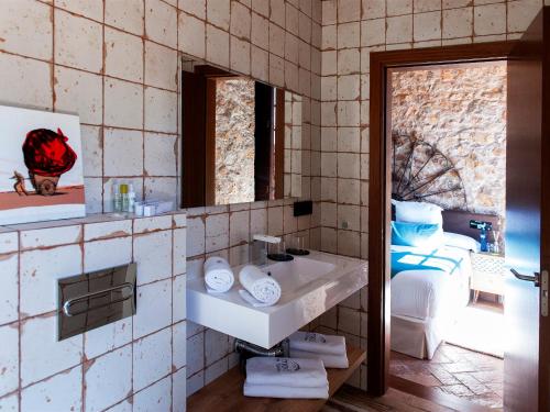 莱斯卡拉Hotel Molí de l'Escala的一间带水槽、床和镜子的浴室