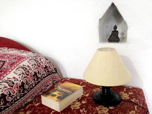 克久拉霍Friends in Khajuraho的床头的台灯和桌子上的一本书