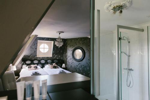 拉纳肯Kasteel Pietersheim的一间卧室设有一张床、一个窗口和淋浴