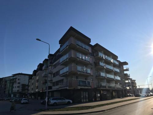 凯尔采APARTAMENT ZAGNAŃSKA - Garaż的公寓大楼前面设有停车位。