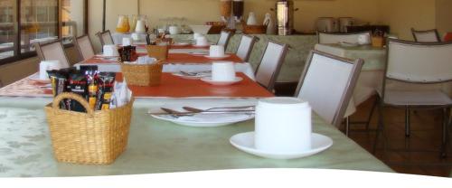 圣地亚哥Alessandria Apart - El Bosque Norte的桌椅和桌子,上面有盘子和饮料