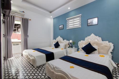 河内Hanoi Boutique House的蓝色墙壁客房的两张床
