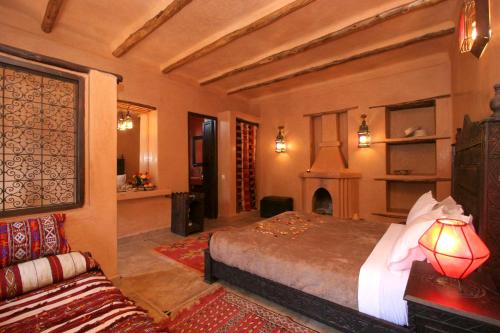 马拉喀什简尼莱拉住宿加早餐旅馆的一间卧室配有一张床、一个壁炉和一张沙发