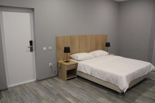 阿斯塔纳Hotel Inju Hills的一间卧室配有一张床和一个带灯的床头柜
