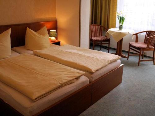 巴特萨克萨乌苏拉酒店-膳食公寓的酒店客房带一张床、一张桌子和椅子