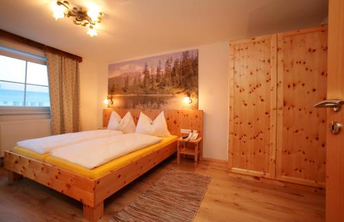 卡普伦外丹曼舍勒公寓酒店的卧室配有一张床,墙上挂有绘画作品
