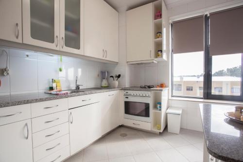 加亚新城Porto Gaia City and Beach by MP的白色的厨房配有白色橱柜和窗户
