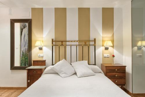 Valbucar伊尔莫林佩特拉酒店的一间卧室配有一张床和条纹墙