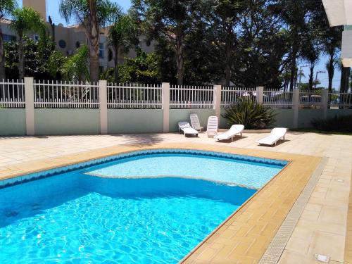 弗洛里亚诺波利斯Brava Apart Hotel的一个带2把躺椅和围栏的游泳池