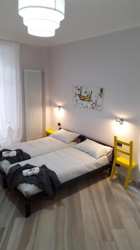都灵Ana's Place Torino 1的一间卧室配有两张床和一张黄色椅子