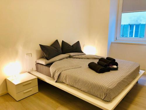 特伦托Casa Bacca apartments的一间卧室配有一张带黑色枕头的大床