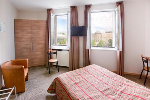 斯特拉斯堡文多姆酒店的酒店客房设有一张床和两个窗户。