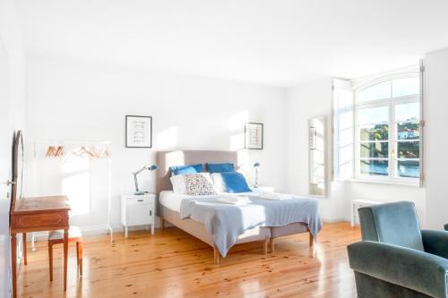 波尔图Douro River Studios的白色卧室配有蓝色枕头的床
