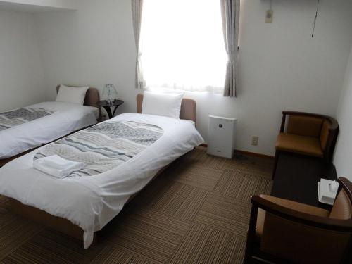 富良野弗拉诺住宿加早餐旅馆的客房设有两张床和窗户。