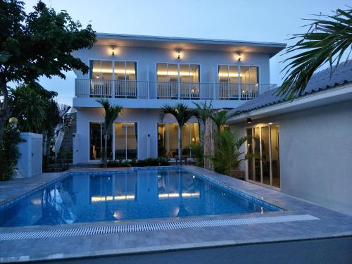 科隆万Sea Sand House Resort的房屋前有游泳池的房子