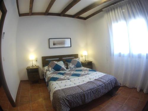 CobisaApartamento los arcos的一间卧室配有一张床、两盏灯和一个窗户。