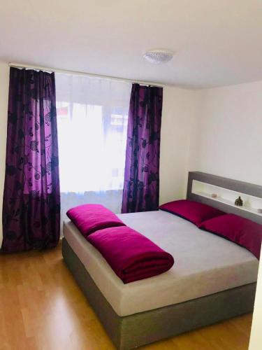 布克斯3 Room Premium Apartment Buchs SG的一间卧室配有一张大床和紫色窗帘