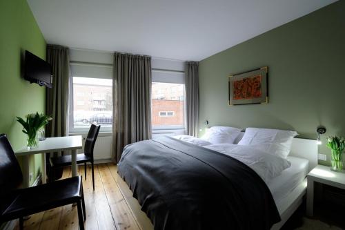 汉堡Hotel KUHBERG Hamburg的一间卧室配有一张床、一张书桌和一个窗户。