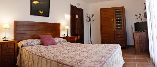 Nohales洛马乡村酒店的一间卧室配有一张大床和木制床头板